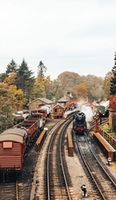 Steam train on train tracks and old-fashioned carriages at Goathland Railway Station