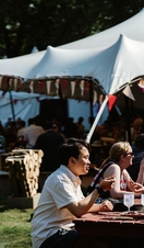 Groups of people sitting at tables and drinking wine at Norwich Wine Festival