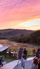 Groups of people watching the sunset at Fforest Farm