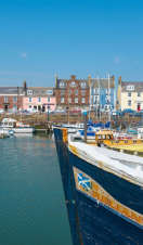 A harbour with colourful houses in the background and small boats in the foreground