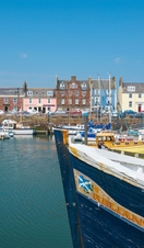 A harbour with colourful houses in the background and small boats in the foreground