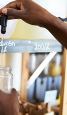 Man filling container from dispenser for body and beauty products