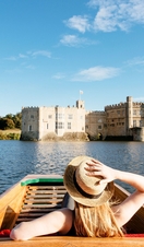 Woman in a punt on the moat looking towards castle