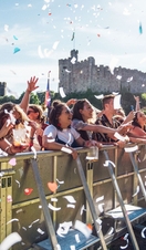 A group of people at the barrier at a music stage at Tafwyl, an annual music festival inside the grounds of Cardiff Castle