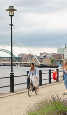 Two men skateboard along the River Tyne in Newcastle