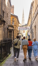 Group of friends walking on a cobbled street.