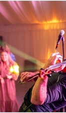 A performer on stage with a violin at the Spirit of Speyside Whiskey Festival