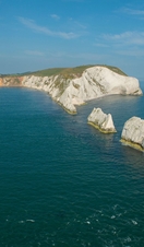 Three chalk sea stacks rising out of the sea. Lighthouse