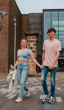 A couple walking past street art outside a museum
