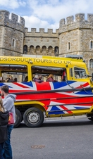A Windsor Duck Tours amphibious vehicle drives past Windsor Castle.