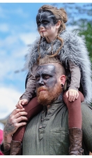 Man carrying child on his shoulders wearing Viking garb and facepaint, Jorvik Viking Centre, York
