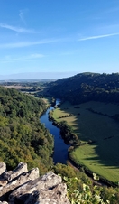 A rocky outlook surrounded by trees with a river below.