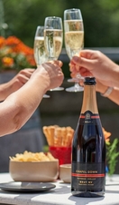 A group of people sat at a table toasting at Chapel Down Winery