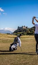A pair of golfers teeing off at Royal St David's Golf Club in Wales