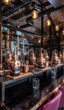 A row of mini gin distilleries set up for tasting sessions at Manchester Gin