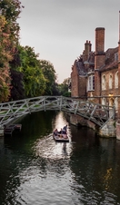 A single punt passes under the Mathematical bridge, in Silver street, Cambridge late on a summer's evening