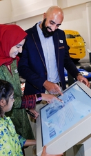 A family looking at an interactive exhibit at the British Motor Museum