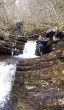 Children using a zipline across a waterfall at Alternative Adventure in Lancashire