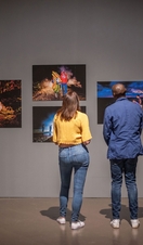 A woman and a man stand looking at an exhibition