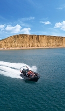 A speedboat carrying a group speeding through the ocean of Lyme Bay