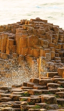 Man and boy sitting on the red basalt columns