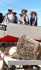 A group of singers in costume outside the Brighton Fishing Museum