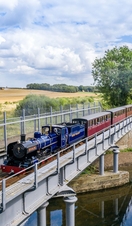 A steam train passing over a river in the Broads National Park