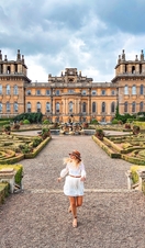 Woman walking in Blenheim Palace gardens surrounded by greenery
