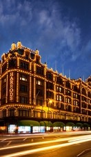Harrods department store lit up at night. Dark skies