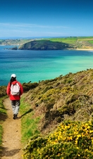 A person on a footpath on the coastal path near sea