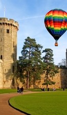 A hot air balloon floats over Warwick Castle in Warwickshire, England.