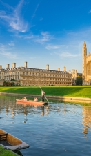 View of college in Cambridge with people punting on River 