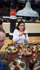 Girl taking a picture of her food at Mackie Mayor