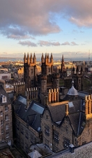 High view of rooftops of Edinburgh with sea beyond as seen from Oscura & World of Illusions attraction