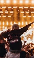 Girl sitting on the shoulders of a guy in the crowd at TRNSMT festival