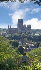 Family walking on a hill top looking down on to Durham Cathedral