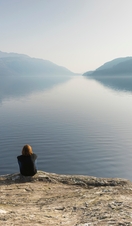 A woman sitting and looking out across Loch Lomond