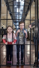 Family pretending to be locked in a cell at Crumlin Road Gaol, Belfast