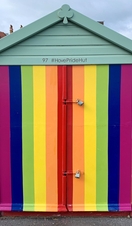A rainbow coloured beach hut on Brighton and Hove beach