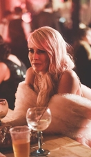 A woman sat at a table with a drink at Depot in Cardiff