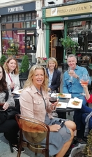 A group of people eating and drinking at an outside table at Cosmo, Cardiff