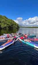 Paddleboarders laying down and forming a shape in the River Clyde in Glasgow
