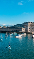 People paddleboarding near a dock in Plymouth