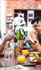 A group of people sitting on a bench eating food at the Storyhouse in Chester