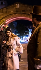 People listening to a tour guide at night as part of a ghost walk in Chester