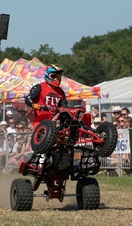 A quad bike doing a stunt in front of a crowd at the Royal Cheshire Show