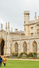 Two women walking across the grounds of a lagre building