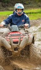 A man riding a quad bike on a muddy track near Stratford-upon-Avon