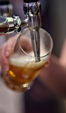 A person pouring a beer from a tapped keg