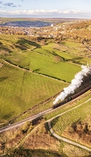 Steam train travelling along tracks in the countryside